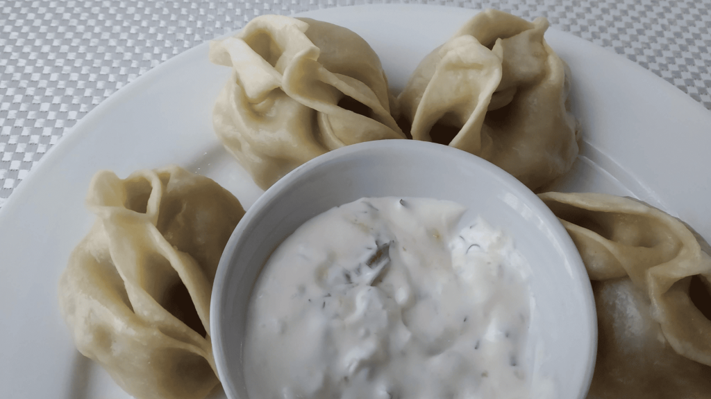 Manty, raviolis vapeur traditionnels servis avec sauce blanche aux herbes en Tchétchénie