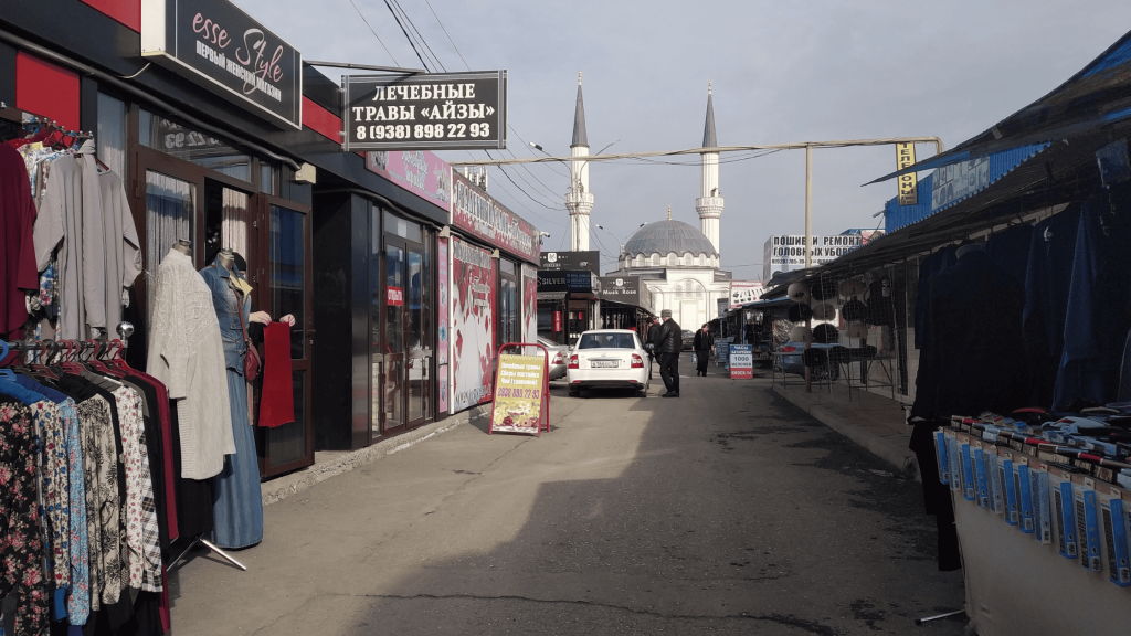 Allée du marché Berkat à Grozny avec commerces et mosquée en arrière-plan
