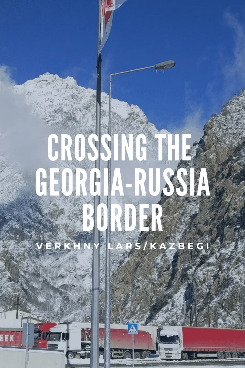 Crossing the Georgia–Russia border at Verkhny Lars near Kazbegi in winter, mountain road with trucks waiting at the border.