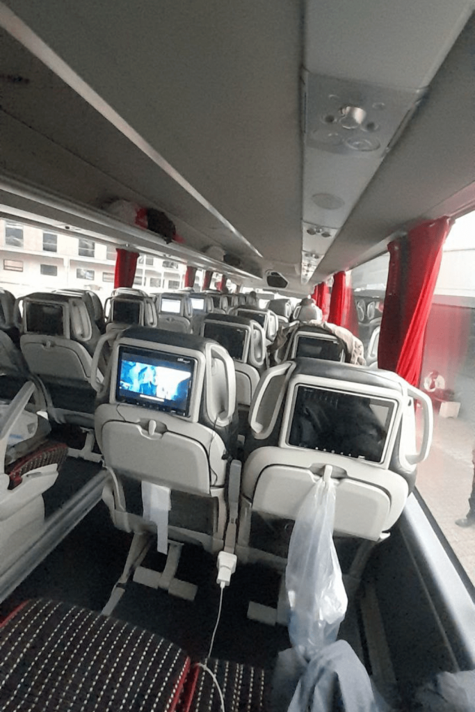 Intérieur moderne d’un bus LuxExpress avec sièges inclinables, écrans individuels et prises USB