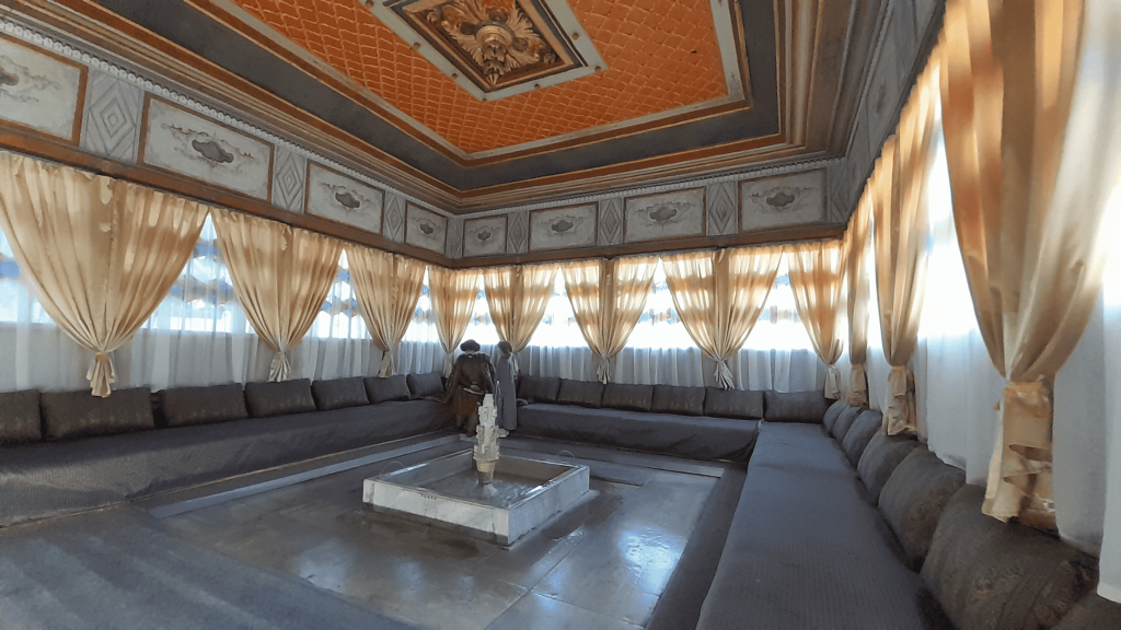 Large hall with cushioned seating along the walls and central fountain in Bakhchisarai Khan Palace