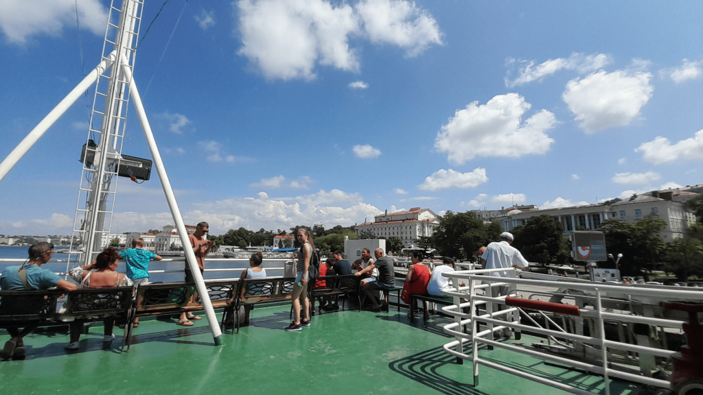 Passengers on a ferry with Sevastopol waterfront in the background