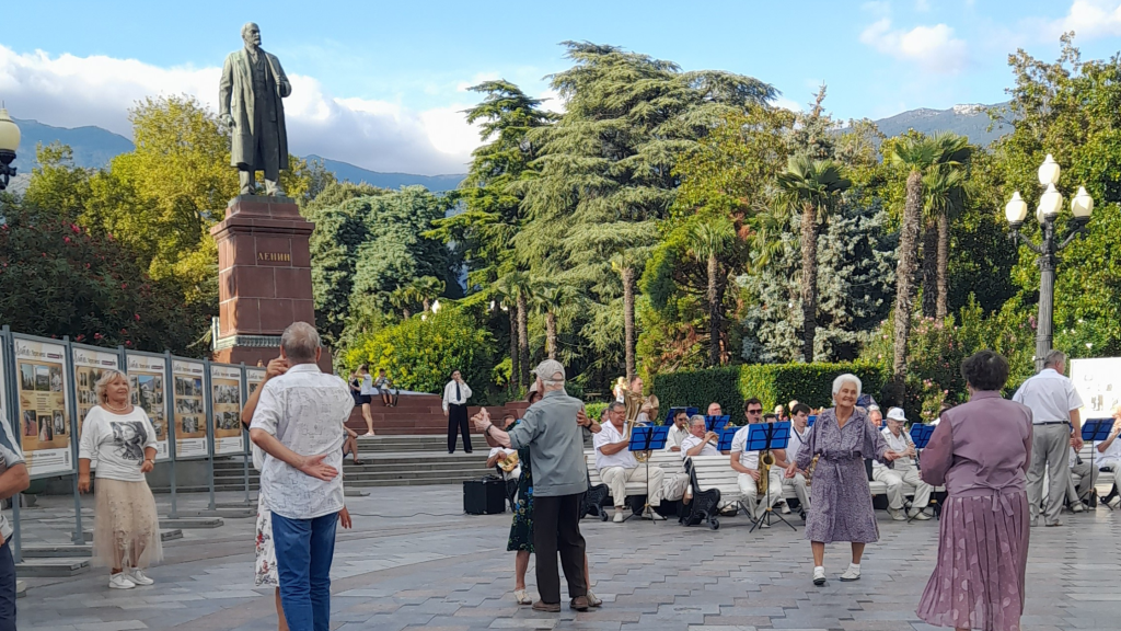 Local residents dancing outdoors in Yalta near a Lenin statue in Crimea