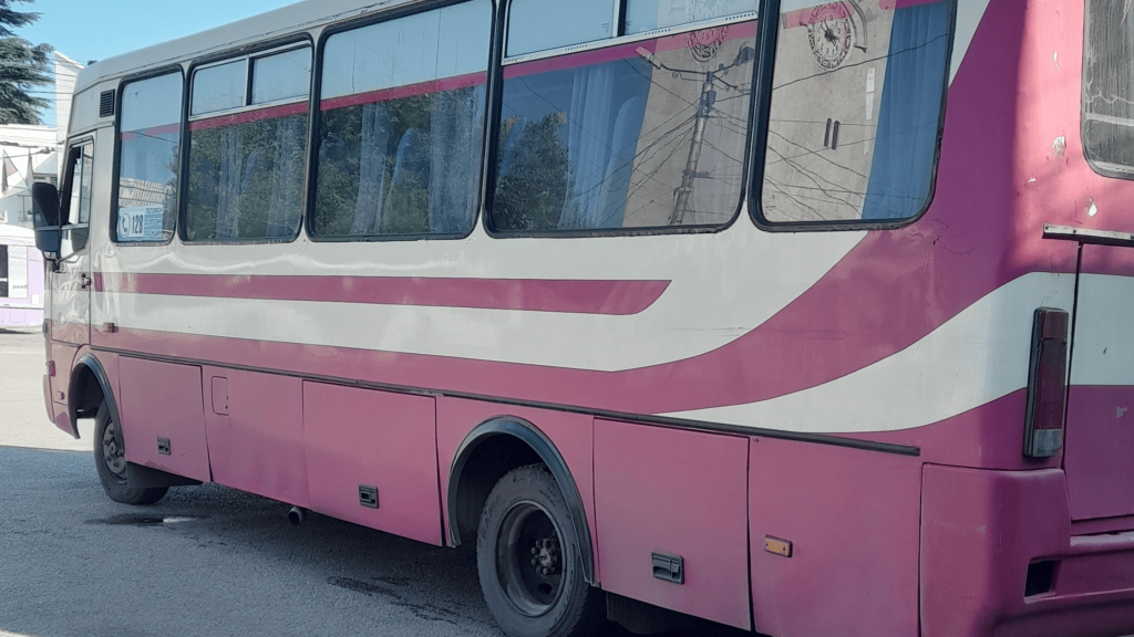 Bus local rose circulant dans une ville de Crimée