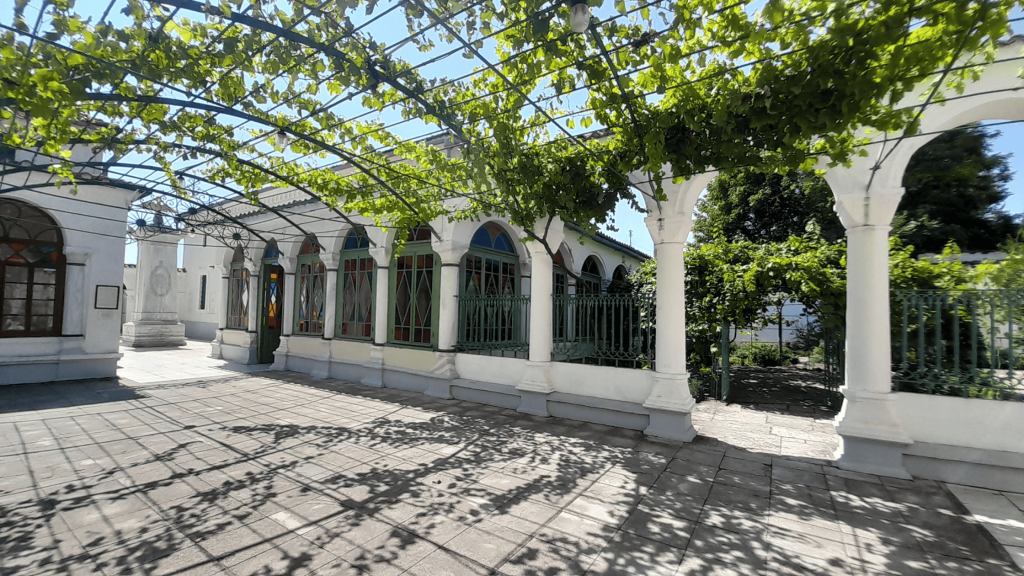 White arcaded courtyard with vine-covered pergola at the Karaite Kenassa in Evpatoria