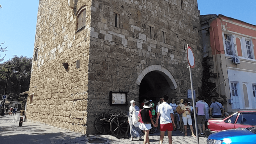 Tour en pierre de la porte de Gezlev avec arche et visiteurs dans le centre historique d’Evpatoria