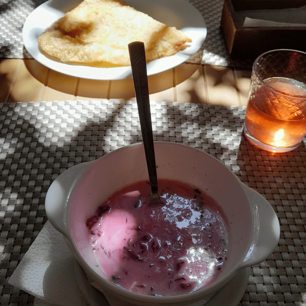 Bol de soupe karaïte froide rose à la betterave accompagné d’un cheburek doré