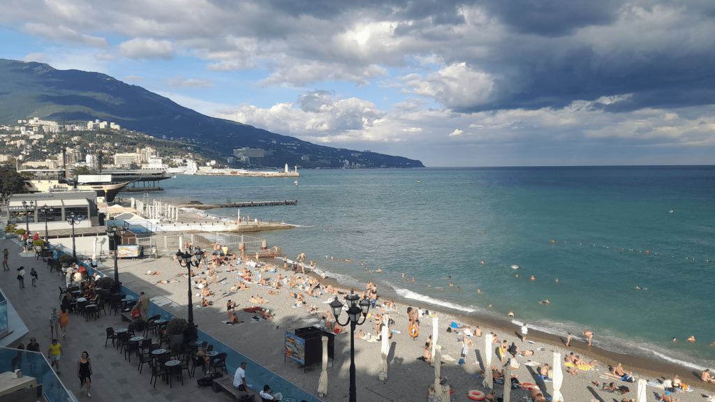 Plage animée de Yalta avec baigneurs et montagnes en arrière-plan sur la mer Noire