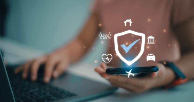 Personne utilisant un ordinateur portable pour demander une assurance voyage Russie en ligne, avec logos d’assurance et avion sur un fond flou.