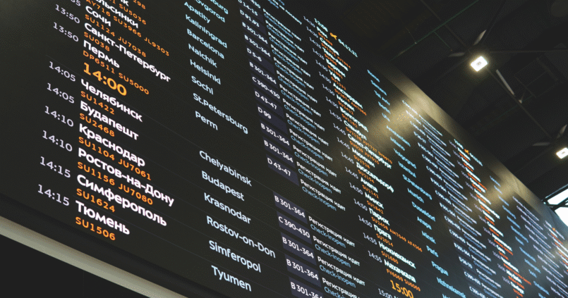 Flight information board and travelers at Istanbul Airport transit zone