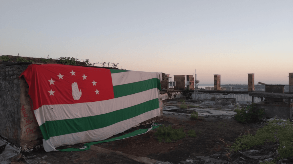 Abkhazian flag hanging on a ruined wall atop the former Georgian parliament building in Sukhumi