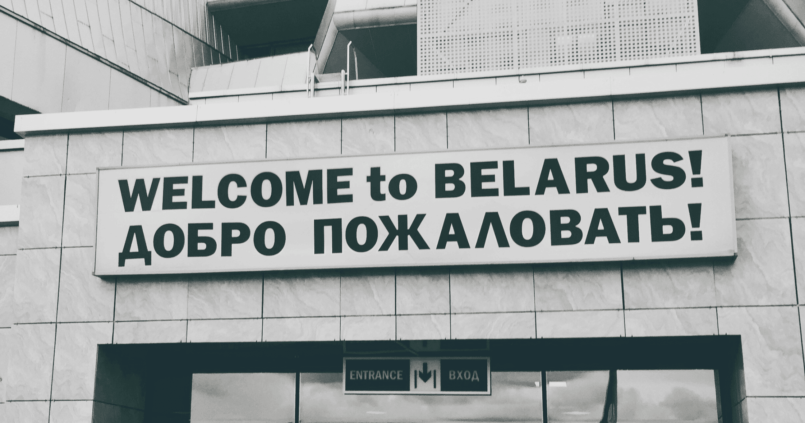 border sign "Welcome to Belarus" in English and Russian at a border crossing between Russia and Belarus.