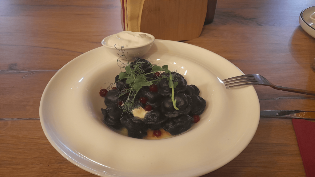 Pelmeni noirs farcis à la viande de renne servis avec crème aigre à Mourmansk en Russie