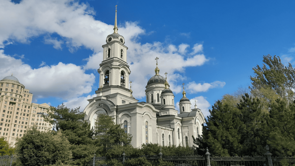 Transfiguration Cathedral in Donetsk with golden domes under a bright blue sky.