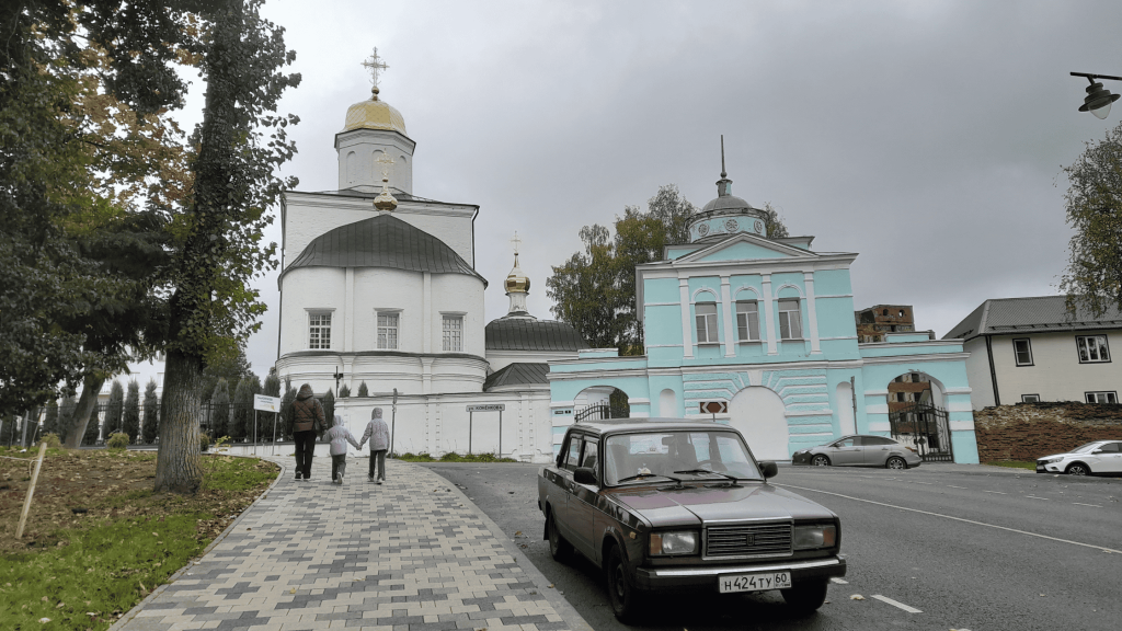 View of the Smolensk convent from Konnaya Street, with an old Lada car parked in the foreground.