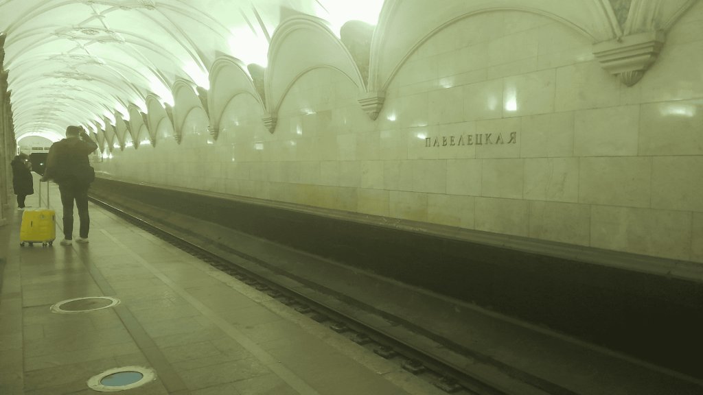 Solo female traveler waiting for train in Moscow metro at night – safe travel in Russia