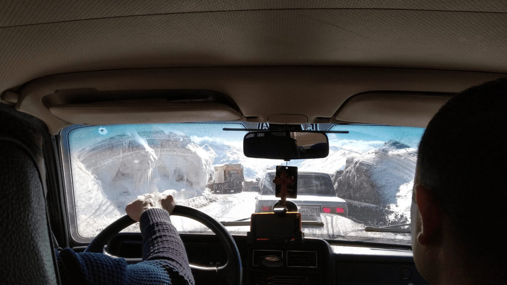 Embouteillage hivernal à la frontière Russie–Géorgie à Verkhny Lars, vu depuis une voiture entre deux murs de neige