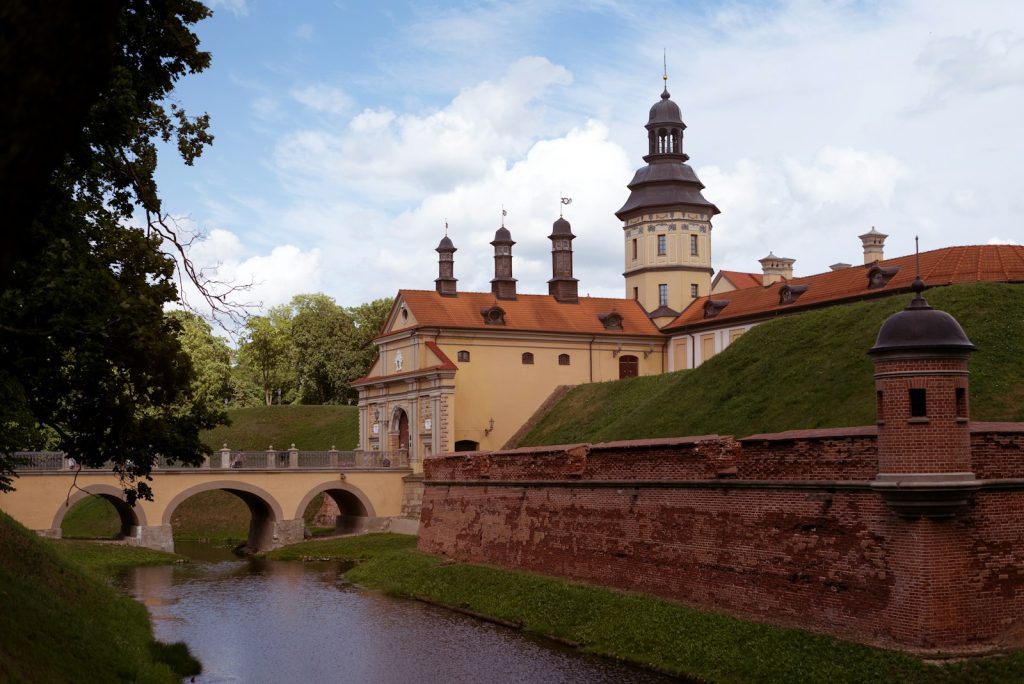 a bridge over a river leading to a large building with towers