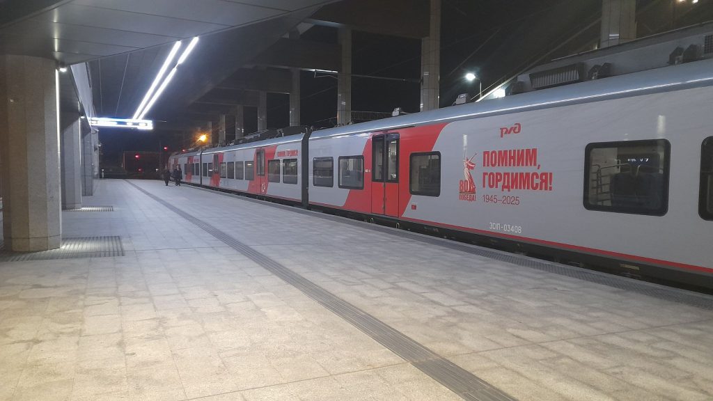 Train moderne à quai dans la gare de Minsk, sur un quai éclairé tôt le matin.
