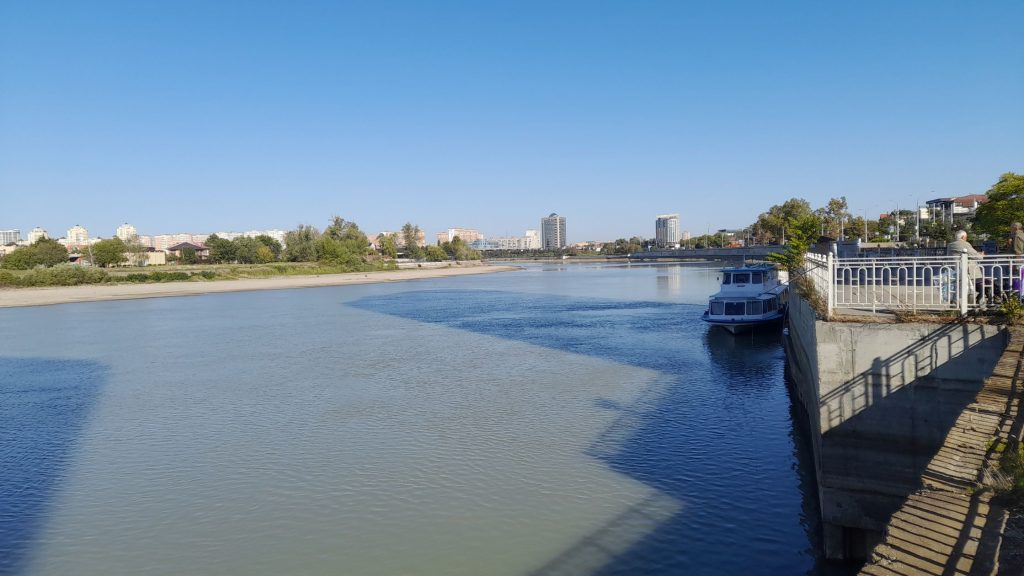 View of the Kuban River embankment in Krasnodar with riverside promenade and boat