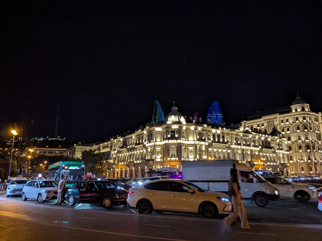 Taxis and buses on a busy street in central Baku at night