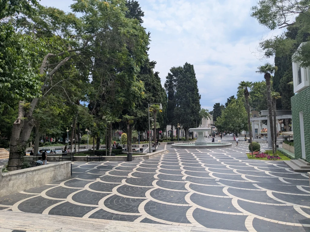 Pedestrian Fountain Square surrounded by trees and historic buildings in Baku