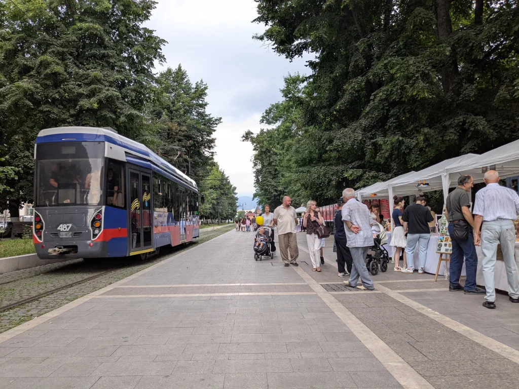 Marché artisanal du dimanche avec un tramway passant sur Prospekt Mira à Vladikavkaz