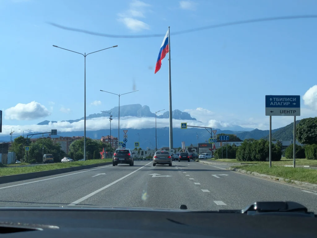 Panneau de Vladikavkaz et drapeau russe avec les montagnes d’Ingouchie en arrière-plan