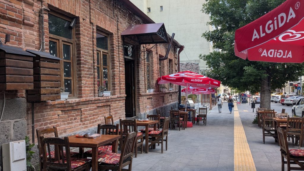 Street lined with restaurant terraces and a Çay Evi in Kars, eastern Turkey